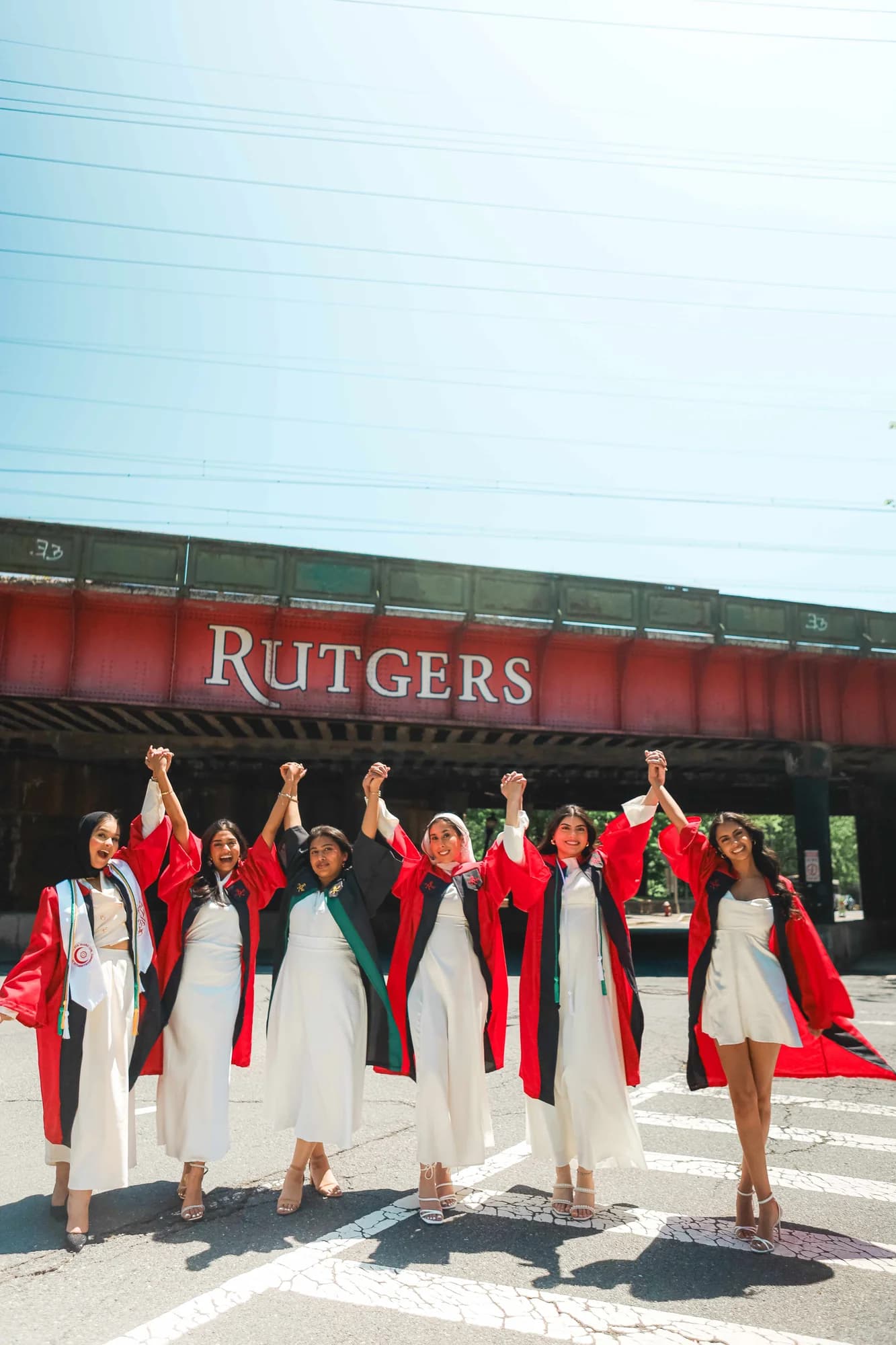Rutgers graduates celebrating under bridge