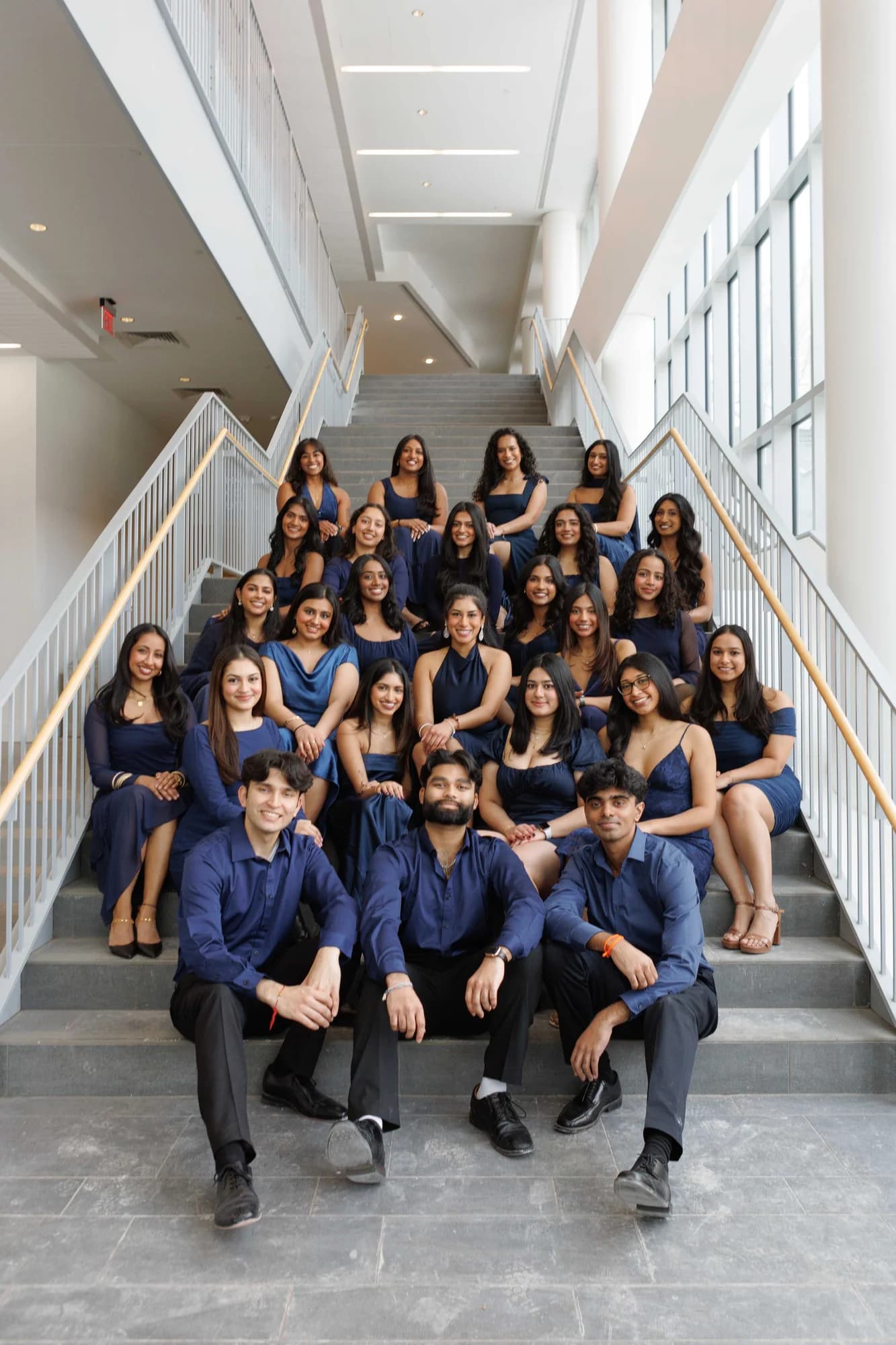 Dance team in navy blue on modern staircase