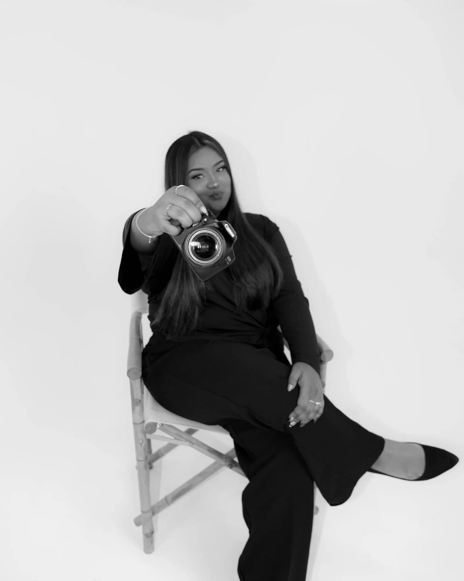 Sana Raza - B&W studio portrait pointing camera